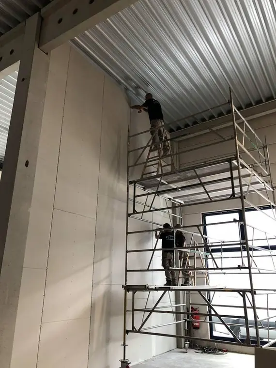 Montage von Gipskartonplatten auf dem Rollgerüst
